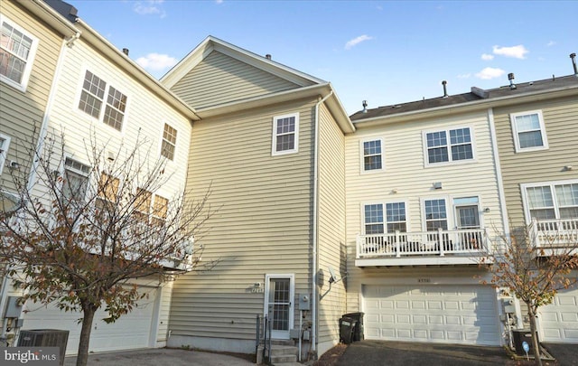 back of property with a garage and central AC unit