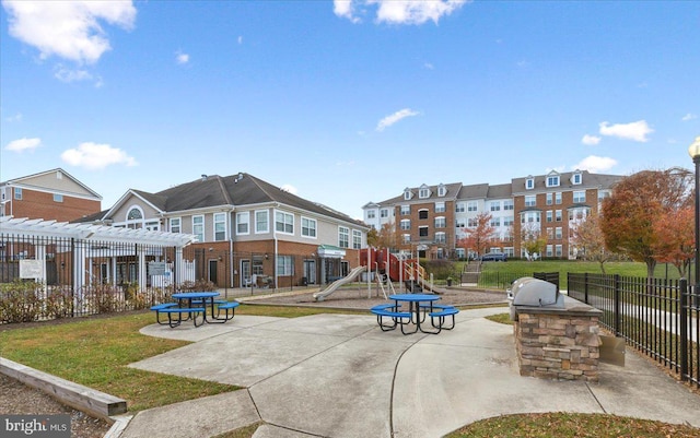 view of property's community featuring a playground, area for grilling, a pergola, and a yard