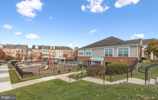 view of home's community featuring a playground and a lawn