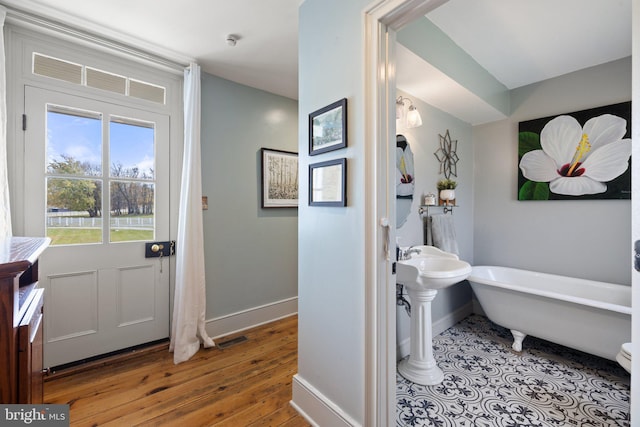 bathroom with hardwood / wood-style flooring and a bathing tub