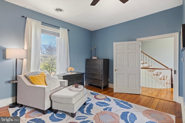 living area featuring wood-type flooring and ceiling fan