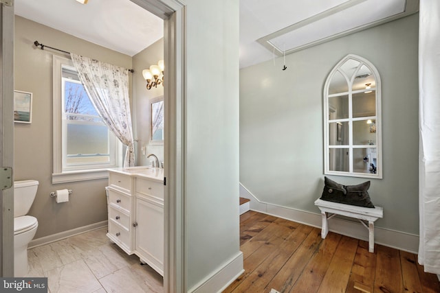 bathroom with toilet, vanity, and hardwood / wood-style floors