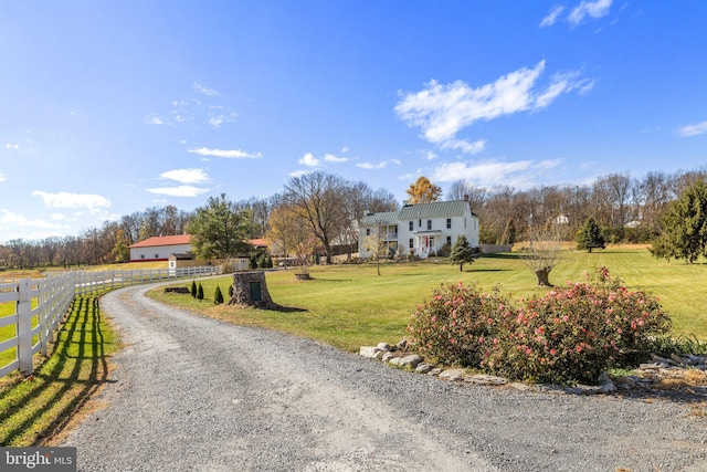 view of front facade featuring a front lawn and a rural view