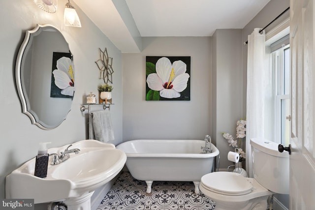 bathroom featuring toilet, tile patterned floors, sink, and a bathtub