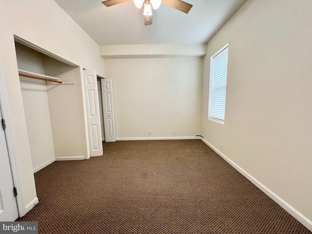 unfurnished bedroom with a closet, ceiling fan, and dark colored carpet