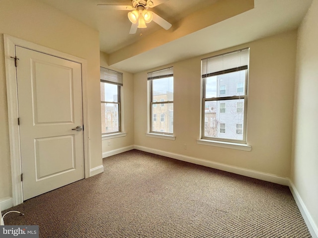 carpeted empty room with ceiling fan and a wealth of natural light