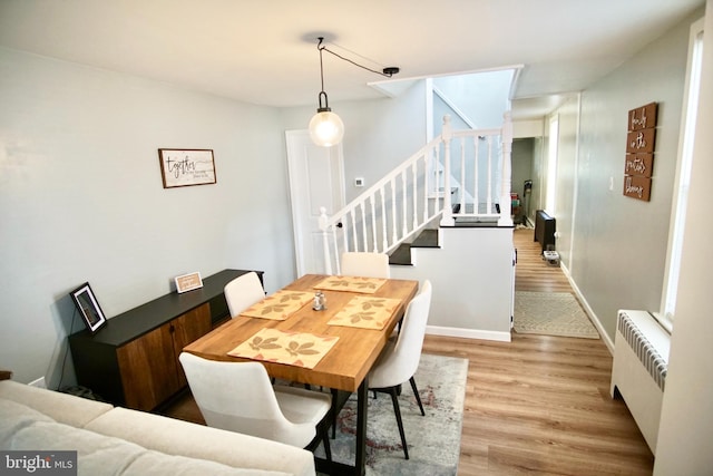 dining space featuring light hardwood / wood-style floors and radiator heating unit