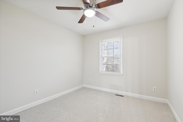 carpeted spare room featuring ceiling fan