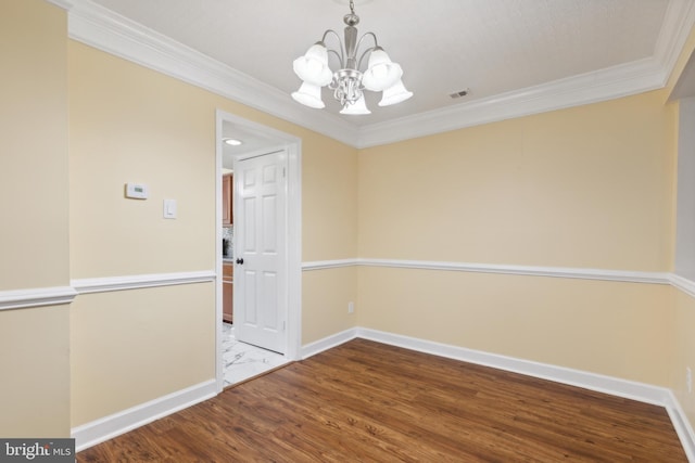 spare room featuring crown molding, hardwood / wood-style flooring, and a notable chandelier