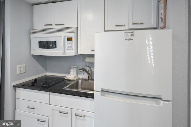 kitchen with white cabinetry, sink, and white appliances