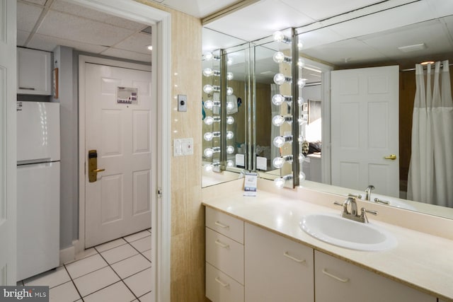 bathroom featuring vanity, tile patterned flooring, and a drop ceiling