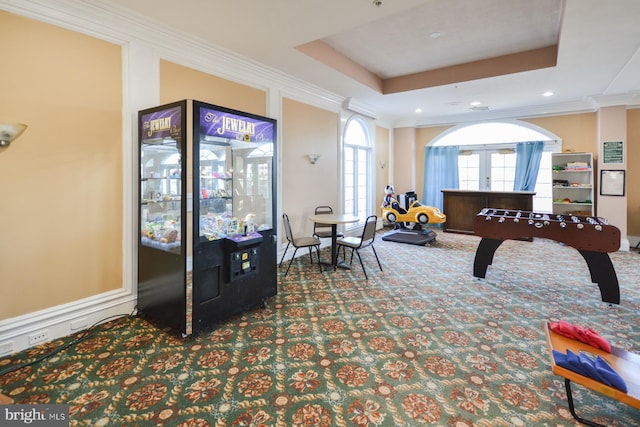 playroom with carpet, ornamental molding, a raised ceiling, and french doors