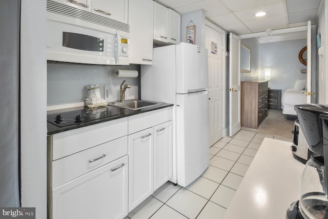 kitchen featuring white cabinetry, sink, white appliances, and light tile patterned floors