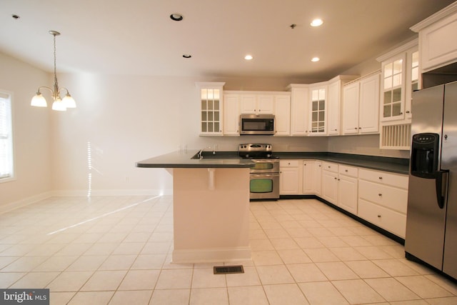 kitchen with decorative light fixtures, white cabinets, stainless steel appliances, and light tile patterned flooring