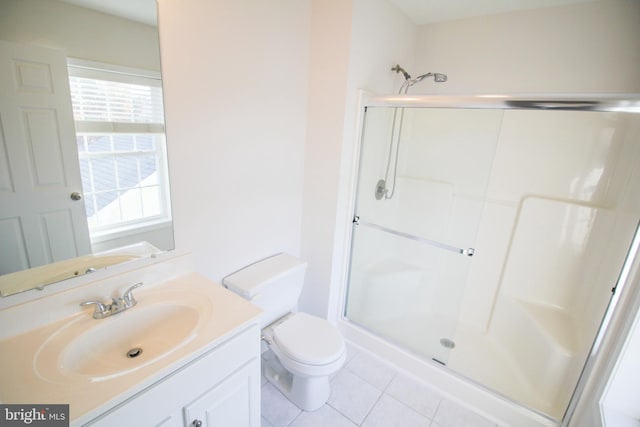 bathroom with vanity, toilet, tile patterned floors, and a shower with door