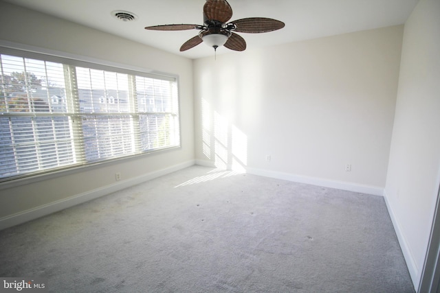 carpeted spare room featuring ceiling fan