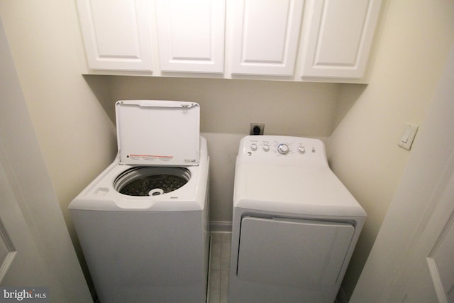 washroom featuring washer and dryer and cabinets