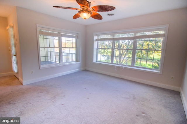 carpeted spare room featuring ceiling fan