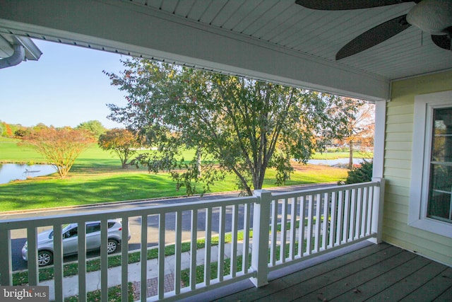 wooden deck featuring ceiling fan and a water view