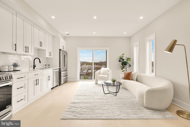 living area with sink and light hardwood / wood-style flooring