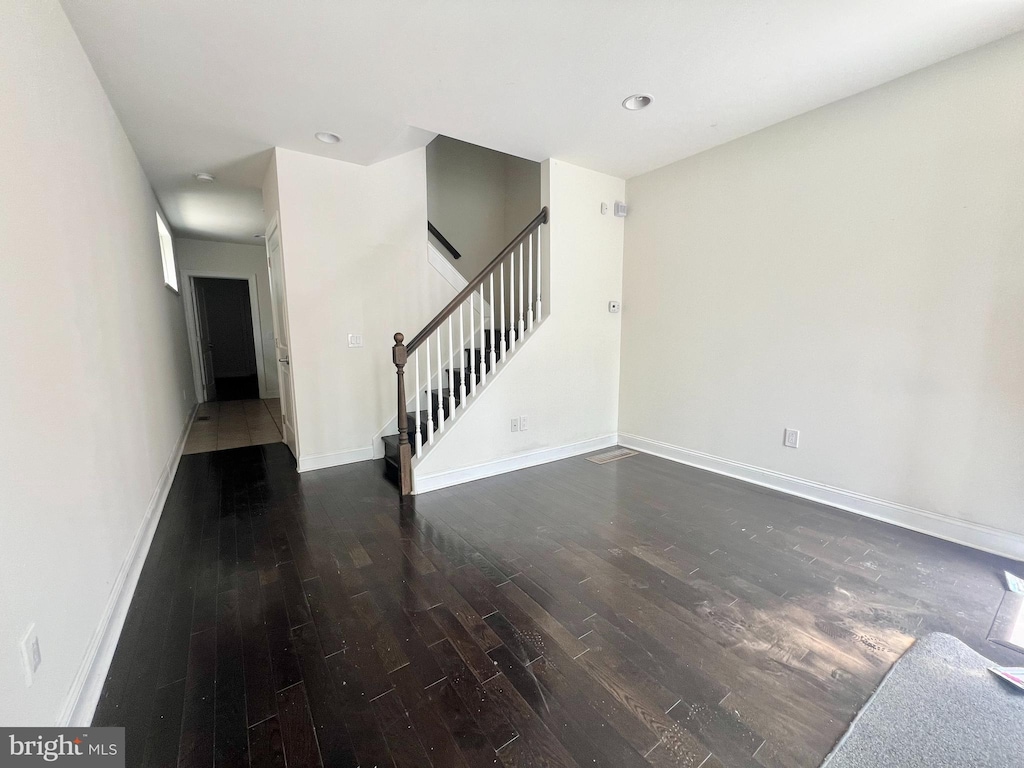 unfurnished living room with dark wood-type flooring