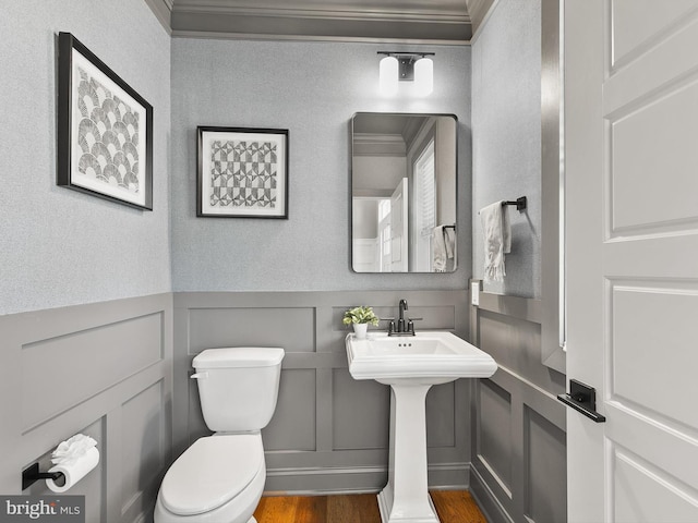 bathroom featuring ornamental molding, hardwood / wood-style floors, and toilet