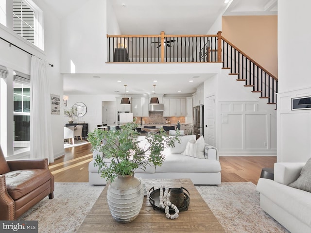 living room featuring high vaulted ceiling and light hardwood / wood-style floors