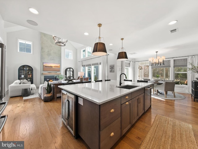 kitchen featuring an island with sink, beverage cooler, plenty of natural light, and sink