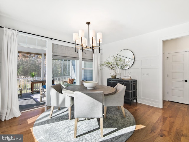 dining area featuring dark wood-type flooring and a notable chandelier