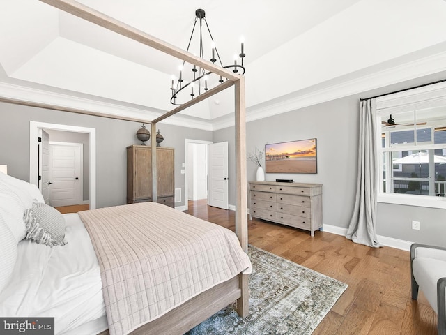 bedroom featuring an inviting chandelier, wood-type flooring, and crown molding