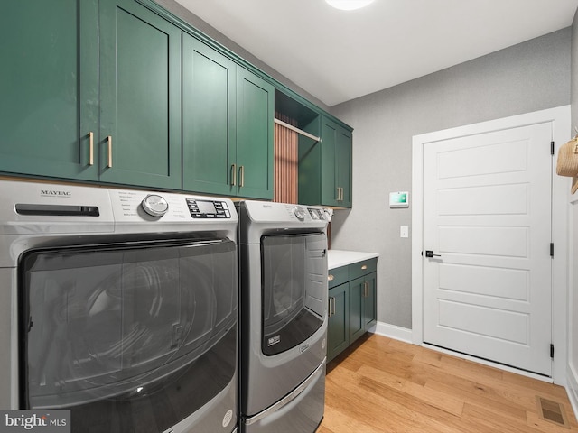 laundry room with cabinets, independent washer and dryer, and light hardwood / wood-style floors