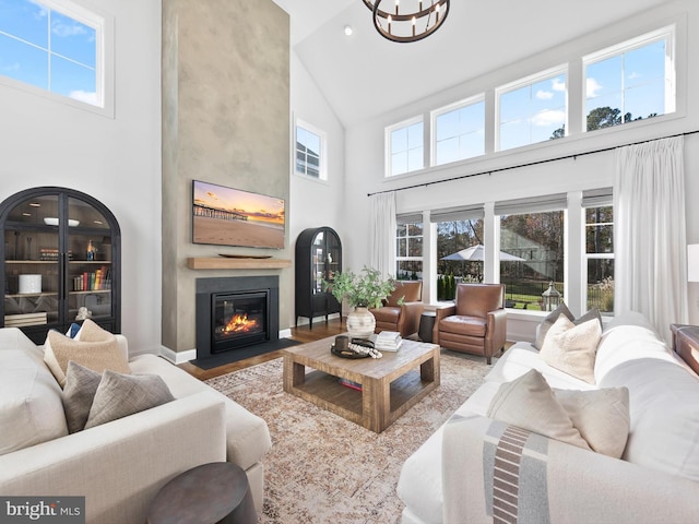 living room with high vaulted ceiling, a wealth of natural light, and a fireplace