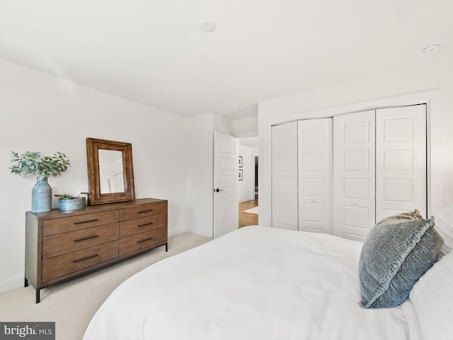 bedroom featuring light carpet and a closet