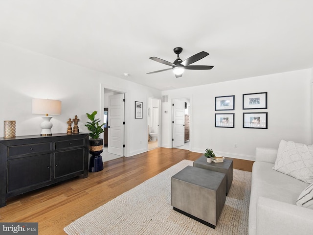 living room featuring light hardwood / wood-style flooring and ceiling fan