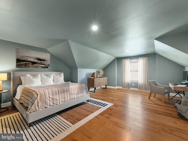 bedroom featuring hardwood / wood-style flooring and lofted ceiling