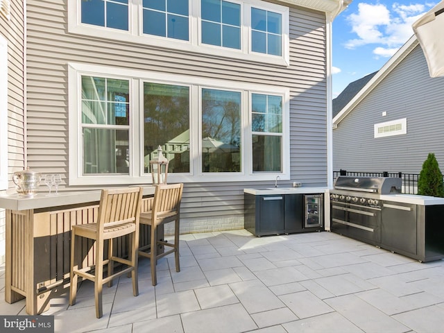 view of patio / terrace with an outdoor kitchen, grilling area, sink, and wine cooler