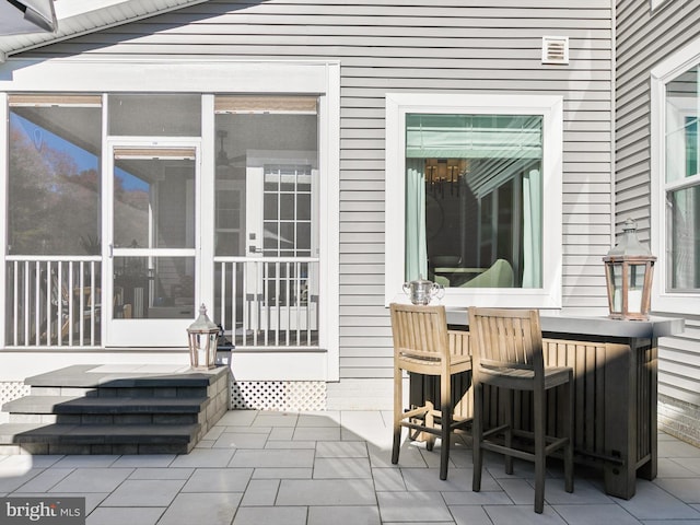 view of patio featuring a sunroom