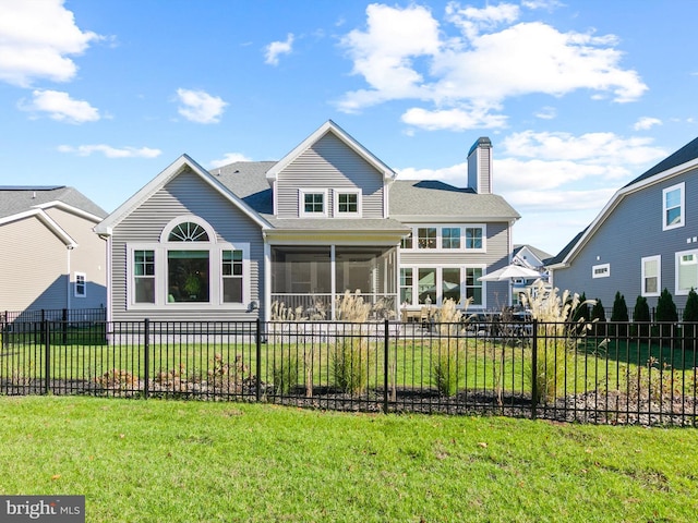 view of front facade featuring a front yard and a sunroom