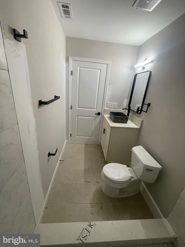 bathroom featuring toilet, vanity, and tile patterned floors