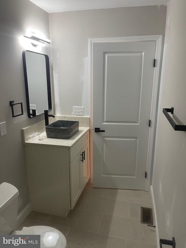 bathroom featuring tile patterned flooring, vanity, and toilet