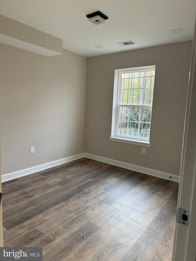 spare room featuring dark wood-type flooring