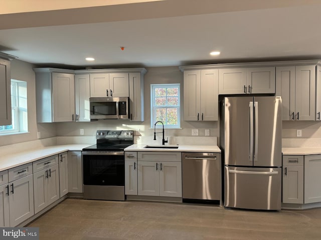 kitchen featuring gray cabinets, stainless steel appliances, sink, and light wood-type flooring