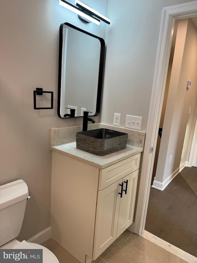 bathroom featuring vanity, tile patterned floors, and toilet