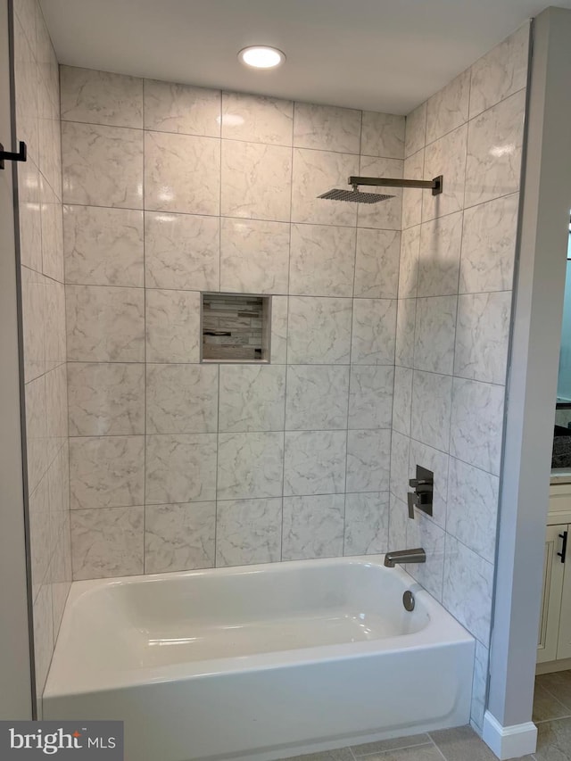 bathroom featuring tile patterned flooring and tiled shower / bath