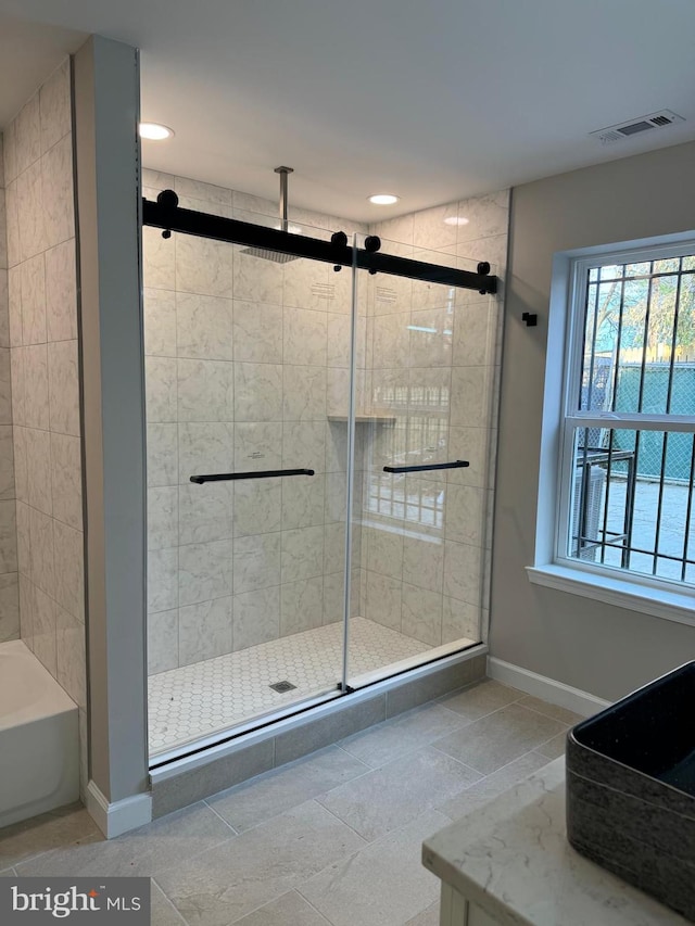 bathroom featuring tile patterned floors and separate shower and tub