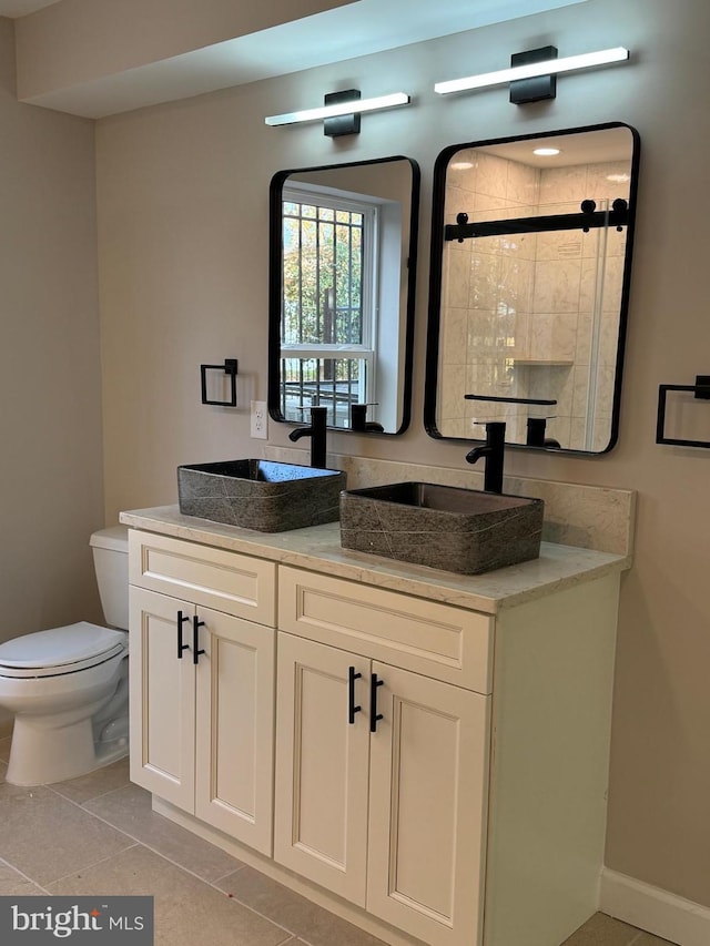 bathroom with walk in shower, vanity, toilet, and tile patterned flooring