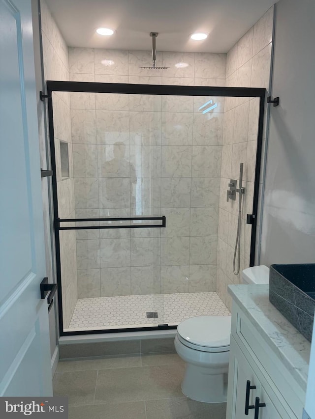 bathroom featuring walk in shower, tile patterned flooring, vanity, and toilet