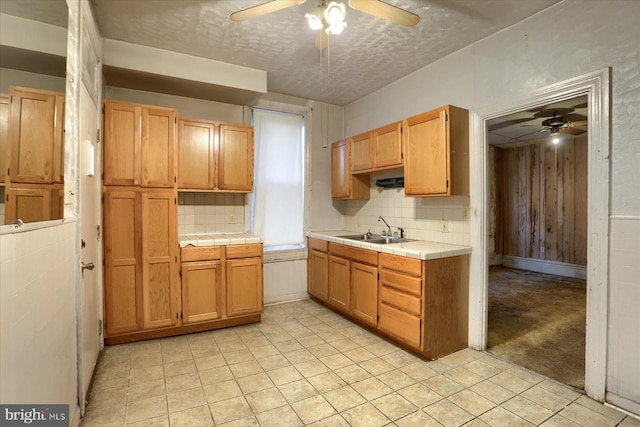 kitchen with sink, light carpet, tile counters, and backsplash