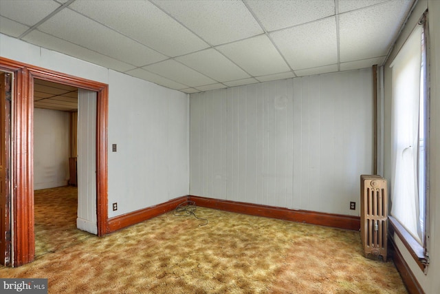 carpeted spare room with a paneled ceiling and radiator