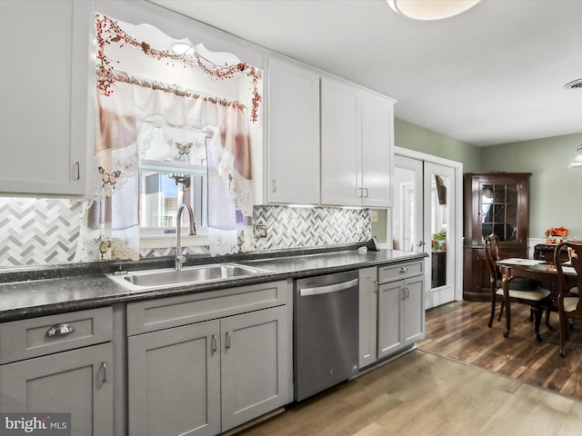 kitchen featuring tasteful backsplash, sink, stainless steel dishwasher, and dark hardwood / wood-style floors